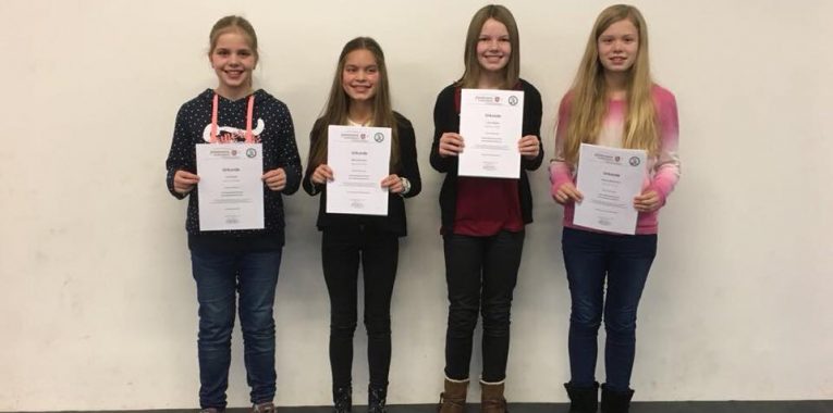 Vier Mädchen halten Urkunden der D1-Prüfung in den Händen.