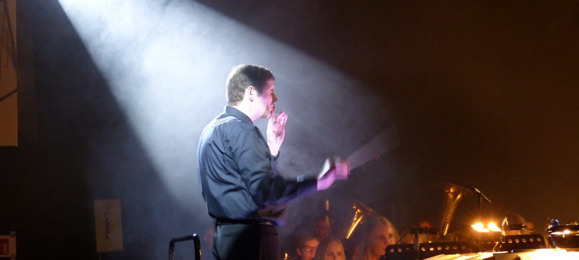 Der Dirigent dirigiert ein Stück.