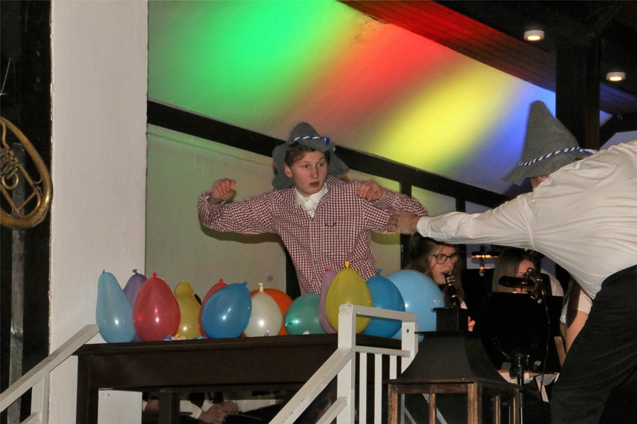 Ein Schlagzeuger der Blaskapelle Schapen lässt Luftballons im Takt platzen.